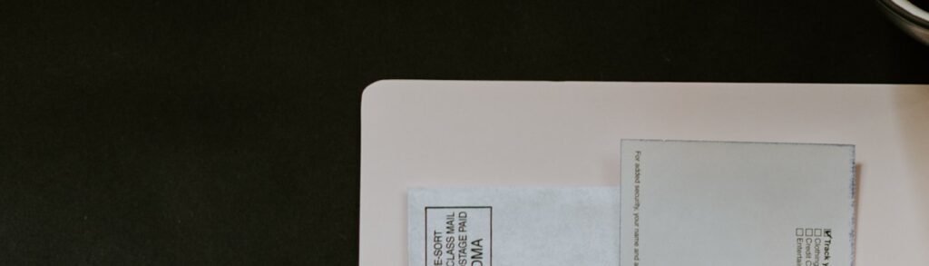Celular, caneta e documento fiscal sobre uma pasta branca, compondo uma cena de organização financeira