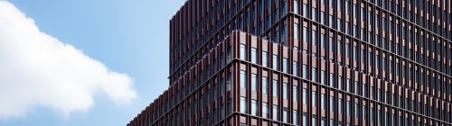 Fachada de um edifício comercial moderno com estrutura escalonada, representando a expansão de uma empresa para uma nova unidade