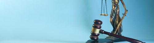 Balança da justiça e martelo de juiz sobre fundo azul