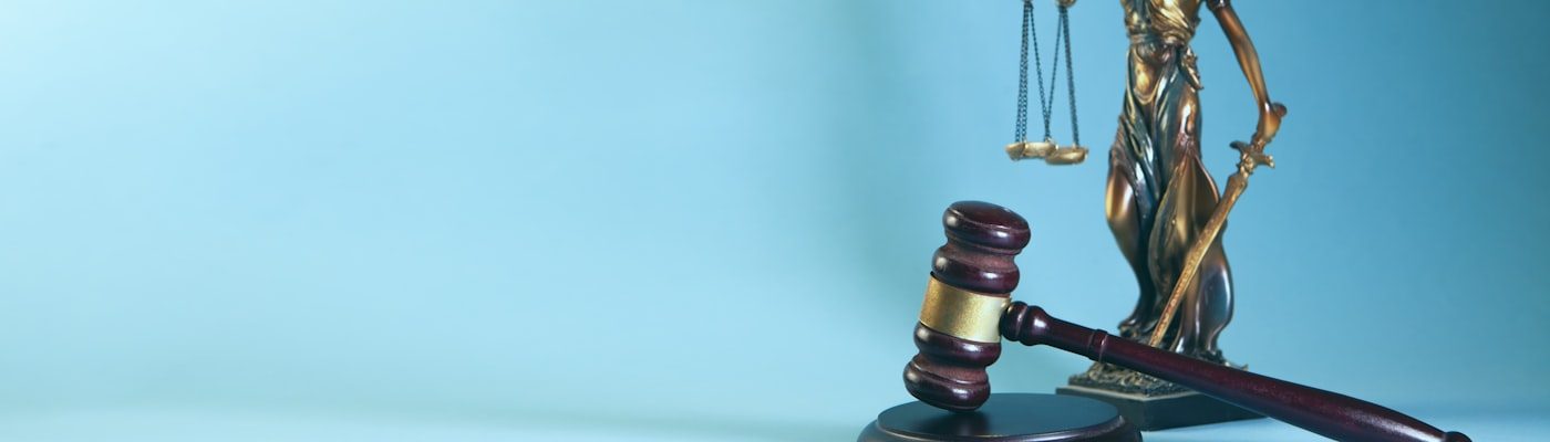 Balança da justiça e martelo de juiz sobre fundo azul